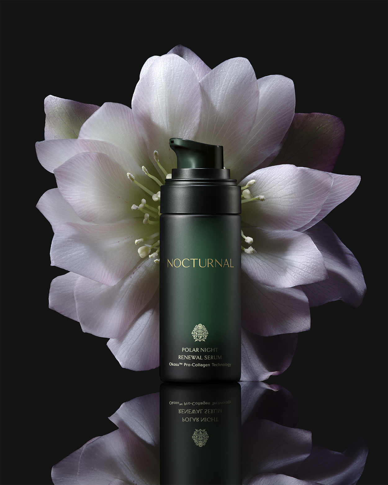 This is full size the Polar Night Anti-aging renewal serum. It is a dark green glass bottle with the cap off. The bottle is sitting in front of a beautiful night blooming flower.