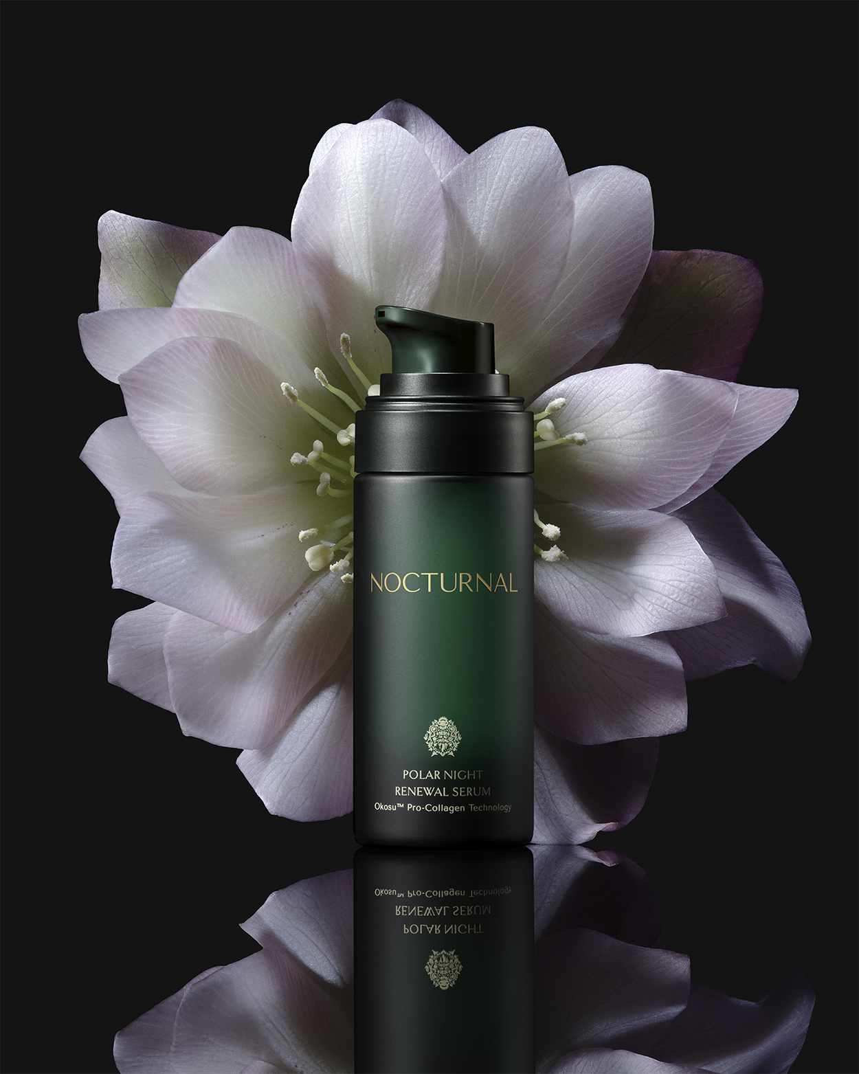This is full size the Polar Night Anti-aging renewal serum. It is a dark green glass bottle with the cap off. The bottle is sitting in front of a beautiful night blooming flower. 